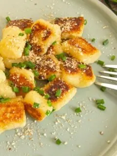Plated Crispy Vegan Gnocchi Topped With Vegan Parm and Chives
