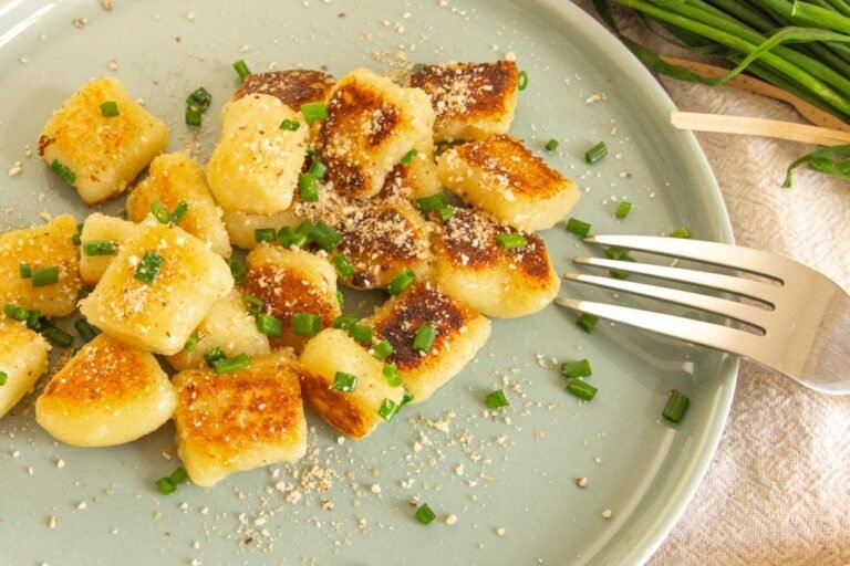 Plated Crispy Vegan Gnocchi Topped With Vegan Parm and Chives