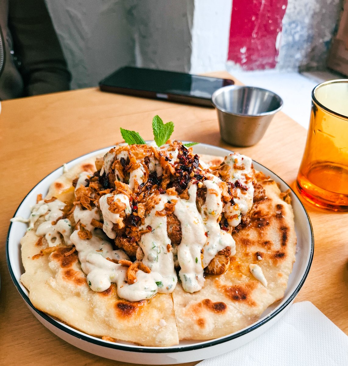 Grasa Vegan Restaurant in Barcelona - Roasted cauliflower on flatbread with yoghurt sauce and mint and chili